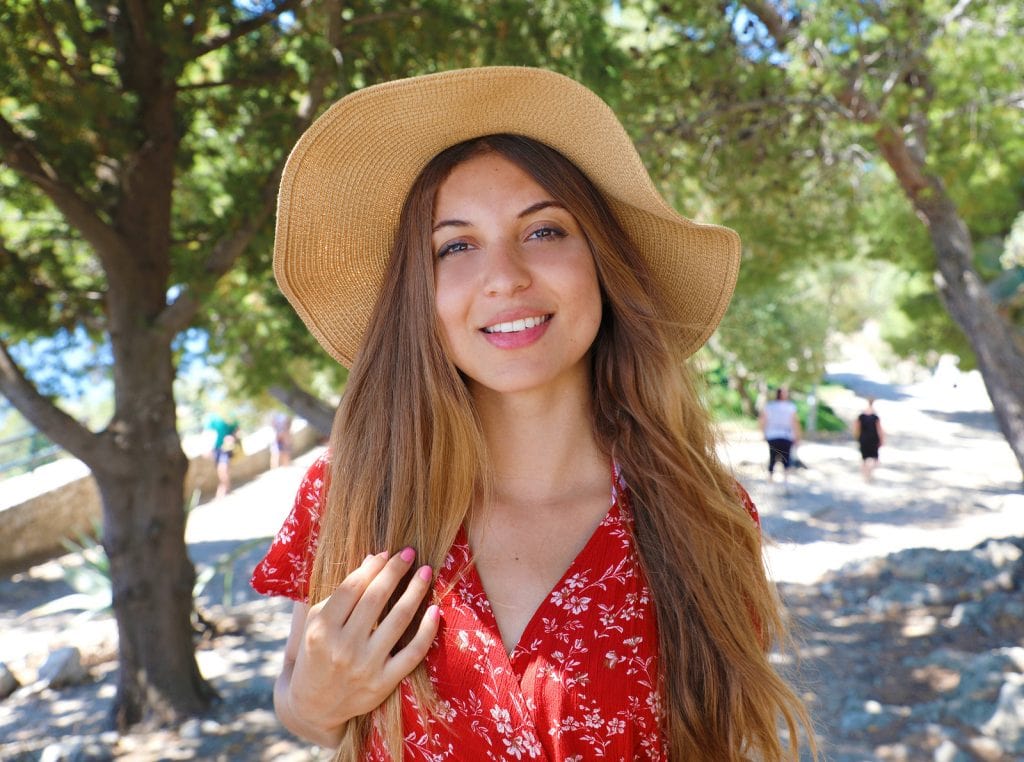 Beautiful Smiling Girl Wearing Red Dress And Hat Looking At Came